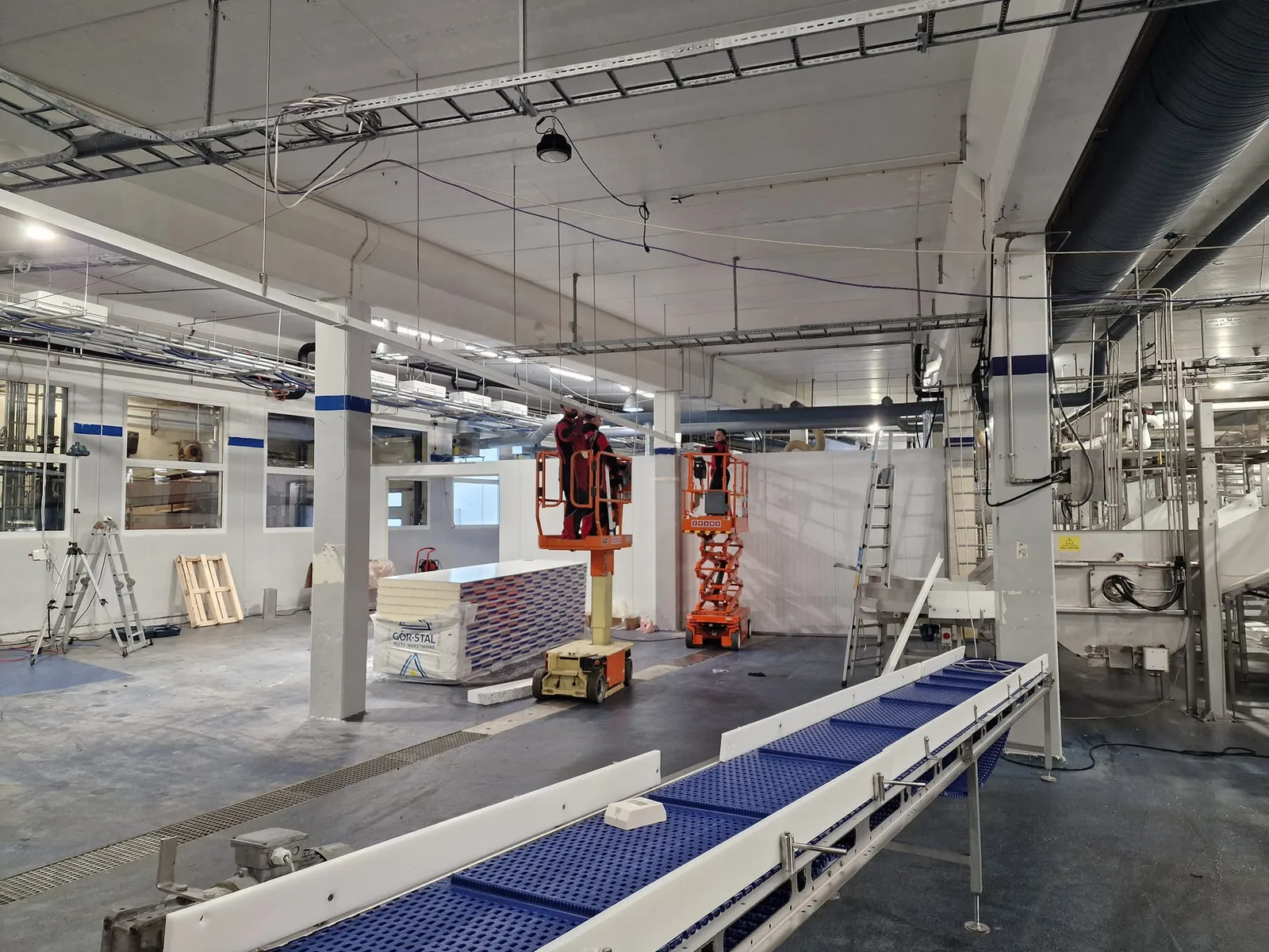 Ny vegg ved transportbånd og produksjonsutstyr